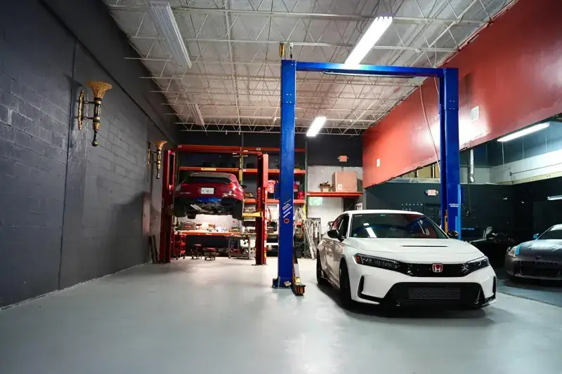 Clean shop floor with a Honda Civic Type R on the lift at Top Car Performance