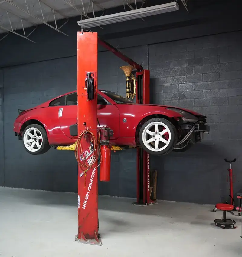 Red sports car on a two-post lift