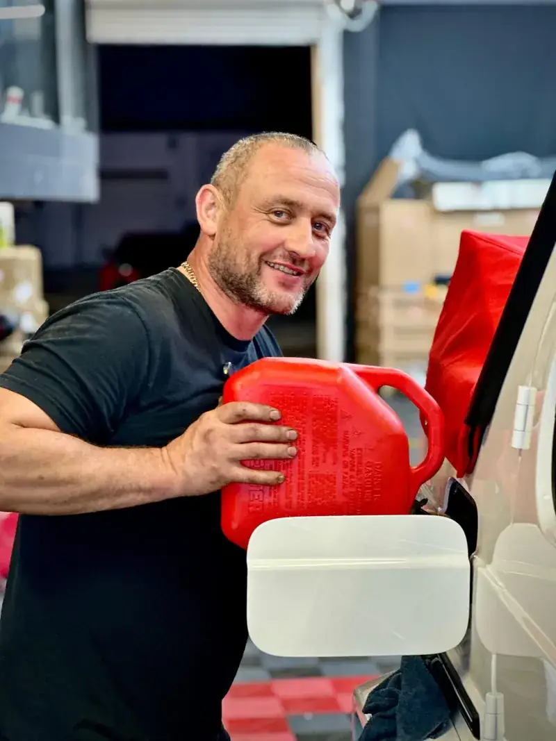 Mechanic with a fluid container during service